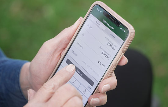 Woman holding phone making transfer