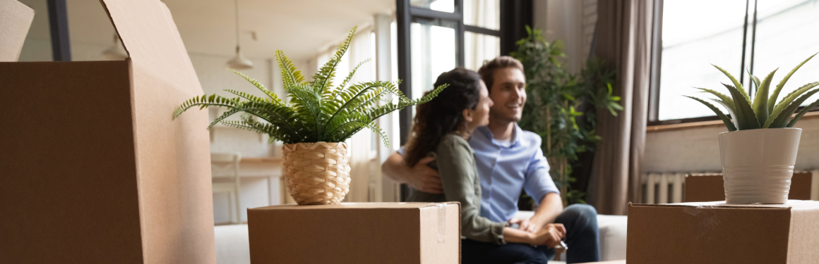 couple sitting in living room with moving boxes